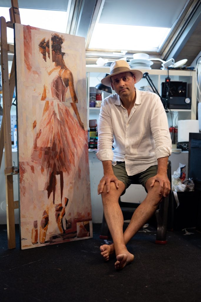Rui Carruço no atelier, junto a uma das suas pinturas